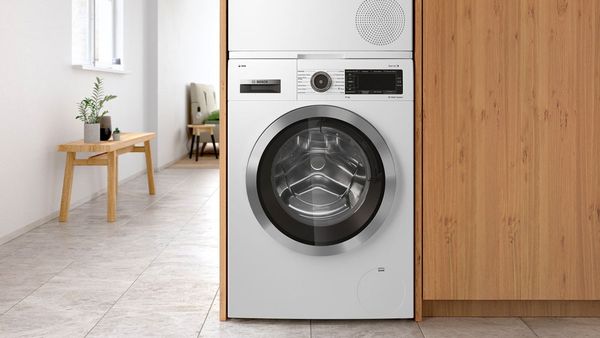 A washing machine and dryer next to each other in a modern bathroom.