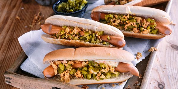 Hot dogs servis sur un plateau, garnis avec différents condiments.     