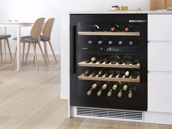 Po stalviršiu montuojamas vyno šaldytuvas su dviem temperatūros zonomis ir nedideliu skandinaviško stiliaus valgomuoju fone.