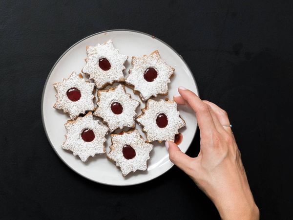 Adding final linzer cookies to a plate