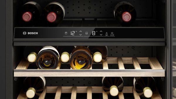 Kahe temperatuuritsooniga veinikülmiku digitaalne juhtpaneel: punane vein ülaosas, valge vein alumistel riiulitel.