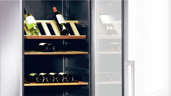 Weinschrank mit geöffneter Glastür und drei Holzablagen mit Weinflaschen.