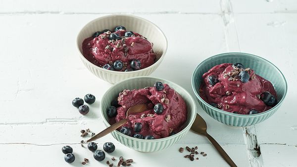Three bowls filled with a frozen cream that is sprinkled with blueberries.
