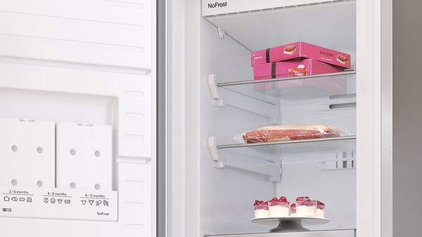 Des pizzas congelées sur une étagère facile d'accès dans un congélateur.