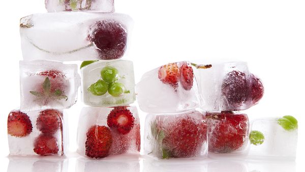 Kaudzē salikti ledus kubi ar saldētiem augļiem iekšpusē