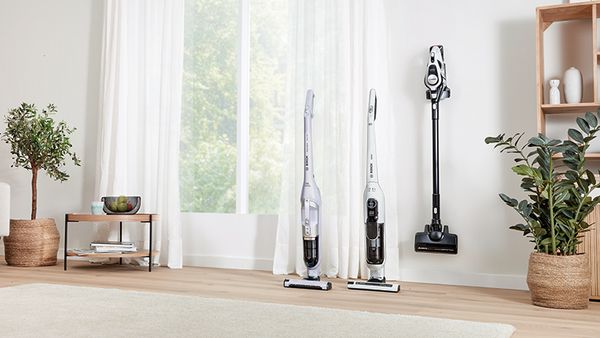Cordless vacuums in a line next to a window