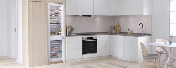 Light kitchen with integrated built in Bosch Fridge Freezer open showing inside contents