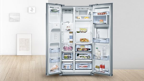 Réfrigérateur américain ouvert, bien garni.