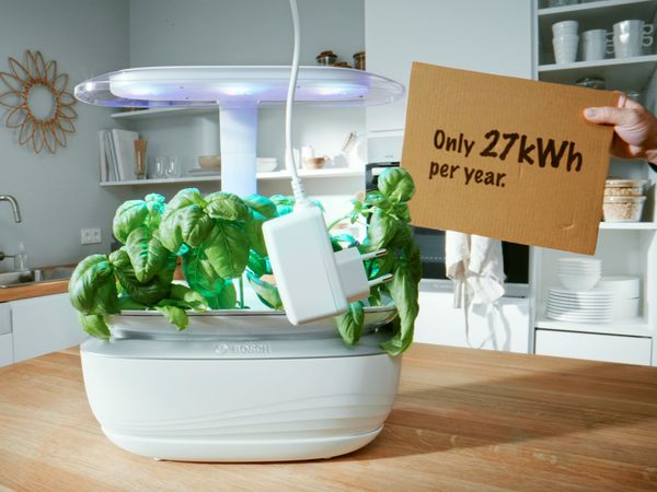 SmartGrow Life sitting on kitchen table with cardboard sign saying only 227kwh per year.