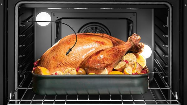 Un poulet au four avec une sonde à viande surveillant la cuisson.