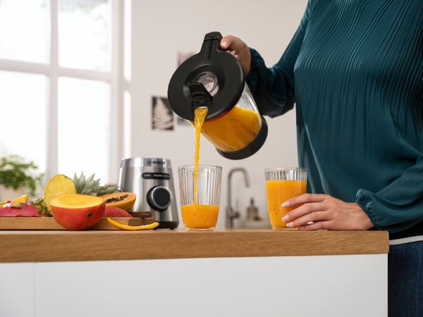 Μια γυναίκα χύνει smoothie σε ένα ποτήρι από το μπλέντερ VitaPower Series 4 της Bosch.