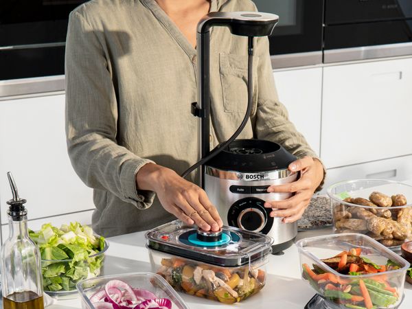 Eine Frau vakuumiert ihre Lebensmittel mit dem Bosch Vakuum-Mixer VitaPower Serie 8.