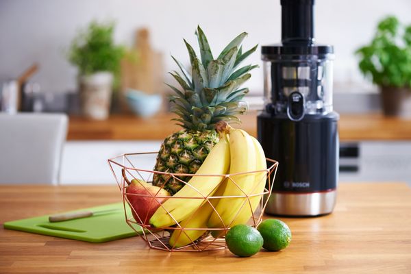 A basket of fruits standing in front of Bosch juicer.
