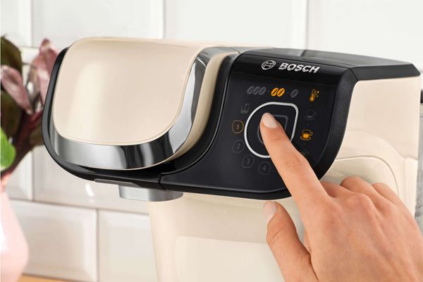 Close-up of a person clicks the start button on the TASSIMO coffee machine MYWAY 2.