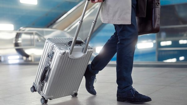Man travelling with small suitcase.
