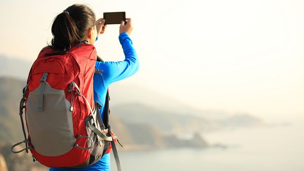 Woman hiking taking a picture.