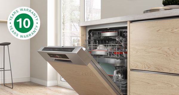 Lave-vaisselle encastrable Bosch dans une cuisine moderne baignée de lumière. L'extension de garantie antirouille gratuite est représentée par l'icône de garantie 10 ans.