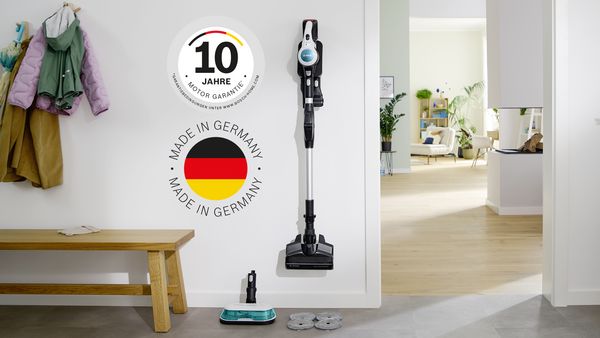 En Bosch Unlimited 7 ProHygienic Aqua som står lent mot en stol med den smarte parkeringsklipsen. Ved siden av ses logoene “Motor Made in Germany” og 10 Years Motor Guarantee.