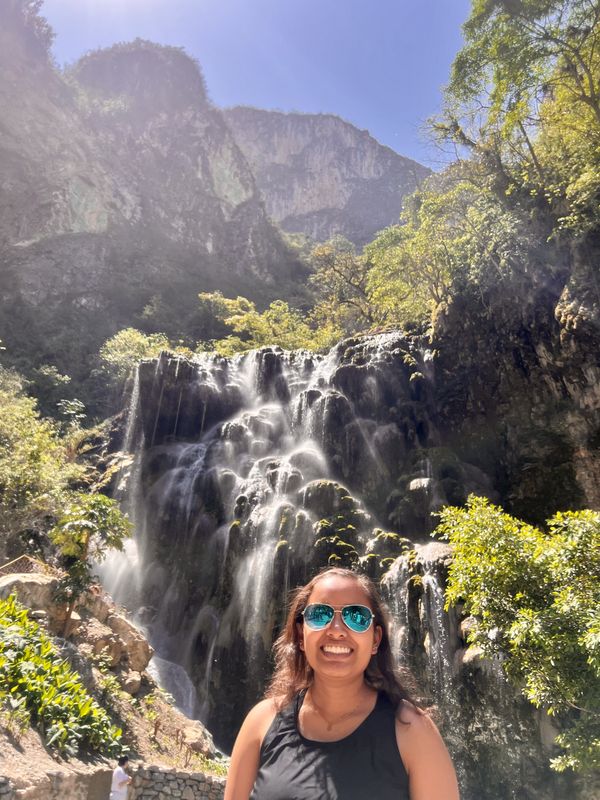 Girl smiling in front of waterfall