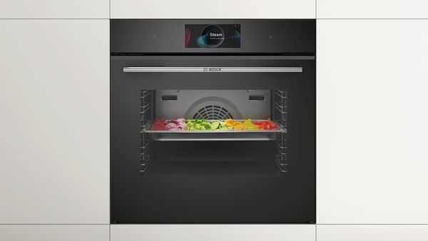 Bosch Series 8 steam oven, in it is a baking tray with various vegetables.