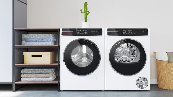 Eine Waschmaschine steht neben einem Trockner.