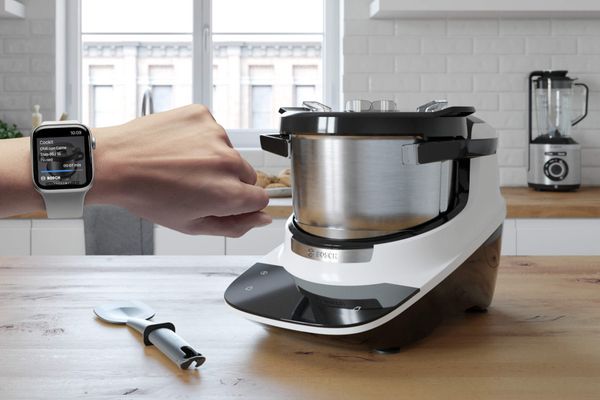Une personne équipée d'une montre intelligente surveille les étapes de cuisson à partir de Cookit.