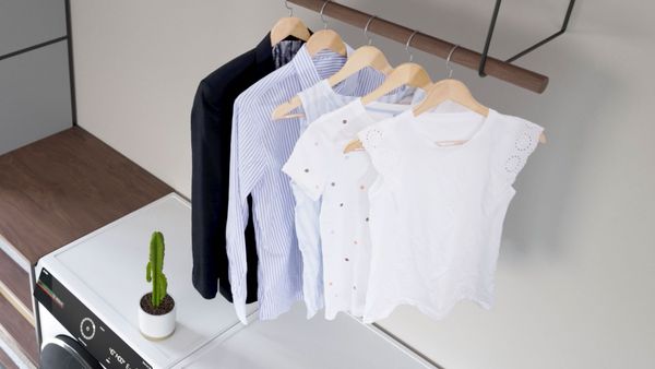 Knitterfreie Kleidung hängt über dem „Serie 8“-Trockner – perfekt sauber und frisch.