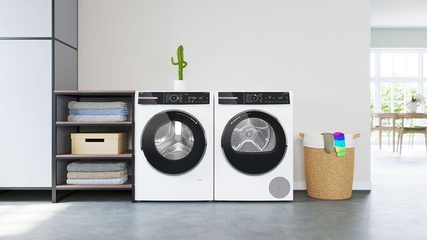 Een Serie 8 droger en wasmachine staan naast elkaar. Op de wasmachine staat een kleine cactus met zijn duim omhoog.