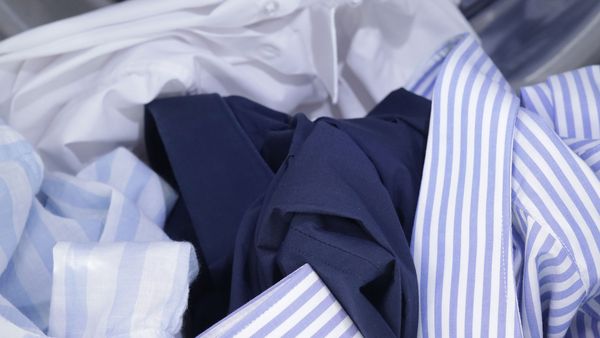 Un tas de chemises sèches de différentes couleurs, séchées délicatement au sèche-linge avec Auto Dry pour leur garantir une longue durée de vie.