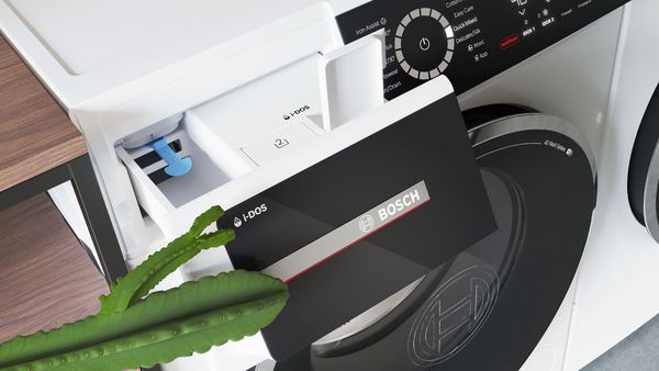 Een kleine groene cactus met armen opent het i-DOS zeepbakje van de Serie 8 wasmachine.