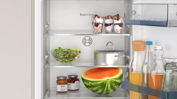 Bosch Einbau-Kühlschrank ohne Gefrierbereich mit geöffneter Kühlschranktür, gefüllt mit Lebensmitteln und Getränken