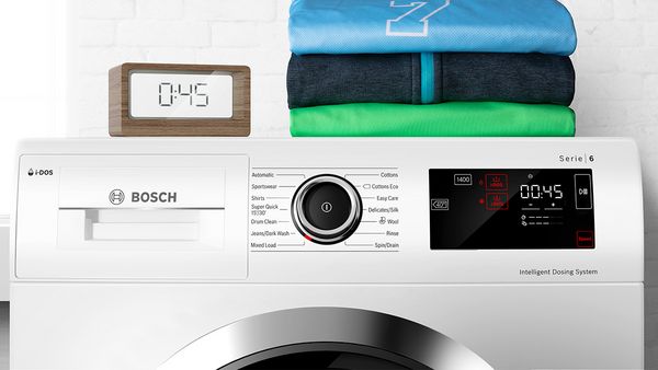 Un timer vicino a una lavatrice Bosch impostato per cronometrare un programma di lavaggio veloce di 45 minuti.