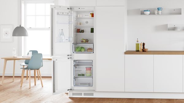Eine moderne weiße Küche mit einer Bosch Einbau-Kühl-Gefrierkombination mit Gefrierbereich unten.