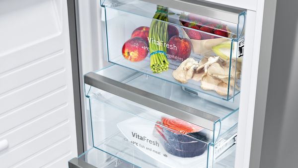 Avoin jääkaappi, jossa on VitaFresh-laatikot, toinen täytettynä tuoreilla vihanneksilla ja toinen tuoreella kalalla.