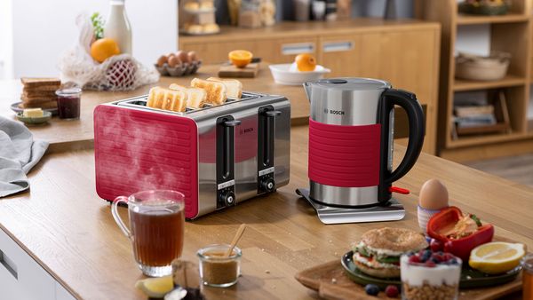 Bosch kettle and toaster in a single design in the kitchen environment: a cup of tea, a sausage with sugar, an egg, a burger, a dessert, jam and toast.