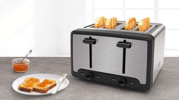 Bosch silver toaster with two slices of toast on a plate with a knife and a saucer with a small spoon and marmalade