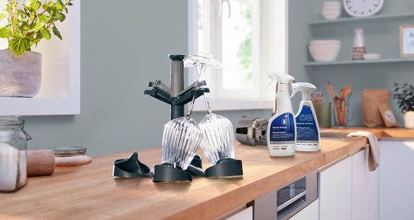 Köksbänk med rengöringsprodukter och en glashållare.