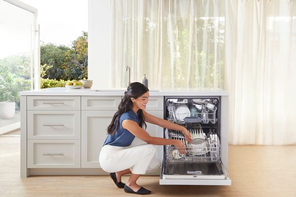 Woman loading dishes into Bosch dishwasher
