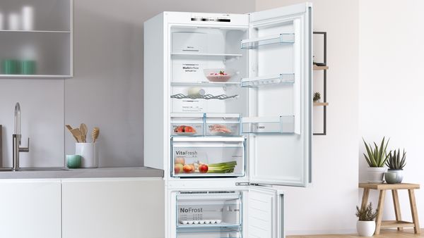 Fridge freezer with doors open showing minimal contents inside