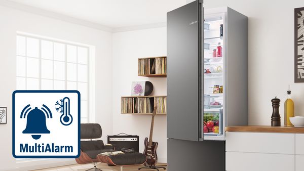 Een foto van een heldere keuken en woonkamer waar de deur van een grote koelkast op een kier is blijven staan, en daar bovenop het MultiAlarm-symbool.