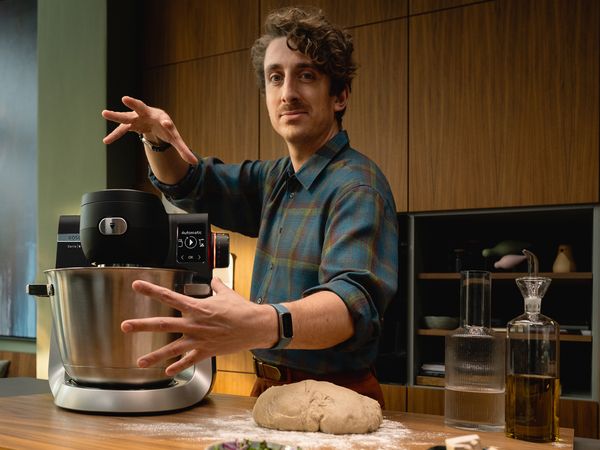 Η κουζινομηχανή Series 6 πάνω στον πάγκο μιας κουζίνας και ένας άνδρας που κάνει μια ταχυδακτυλουργική κίνηση με τα χέρια του.
