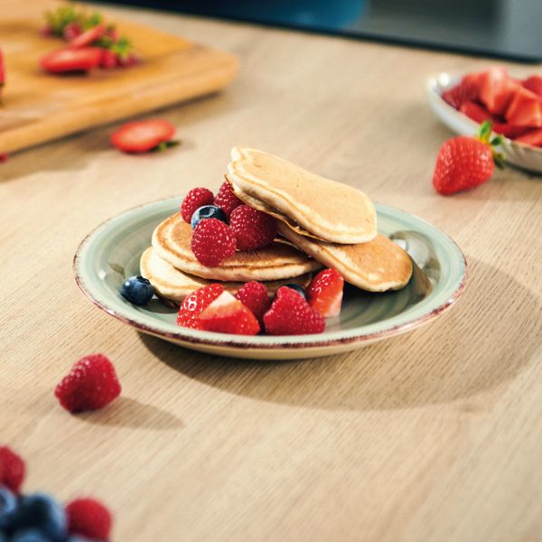 Stack of pancakes on a plate with berries