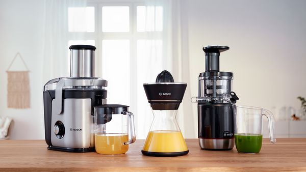 Line up of two Bosch juicers on a kitchen worktop.