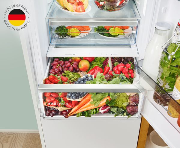 Einbau Kühl- und Gefrierschrank von Bosch voll frischer Lebensmittel; Made in Germany-Logo
