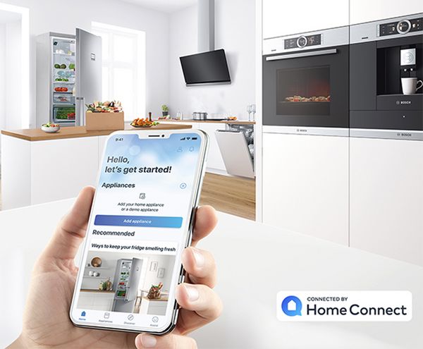 Person setting up Home Connect app on phone in kitchen