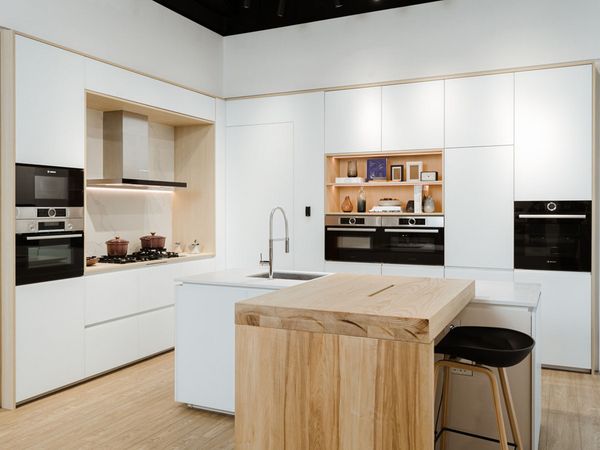 Brightly lit Bosch showroom displaying a kettle, dishwasher, built-in oven and red fridge