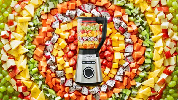 Блендер VitaPower Серия 4 с нарязани плодове и зеленчуци, оформящи многоцветни кръгове около уредите.