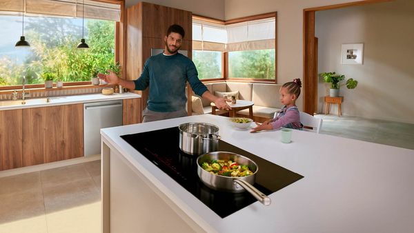 Table de cuisson à induction Bosch avec nourriture et famille