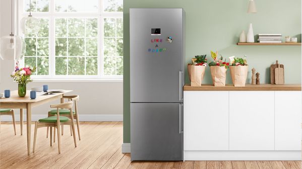 Réfrigérateur argent pose-libre Bosch dans une cuisine blanche.