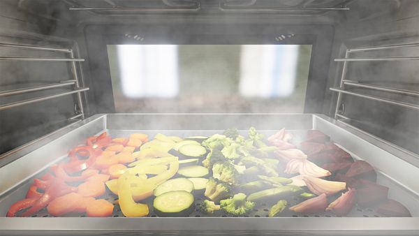 Array of vegetables cooking inside steam oven
